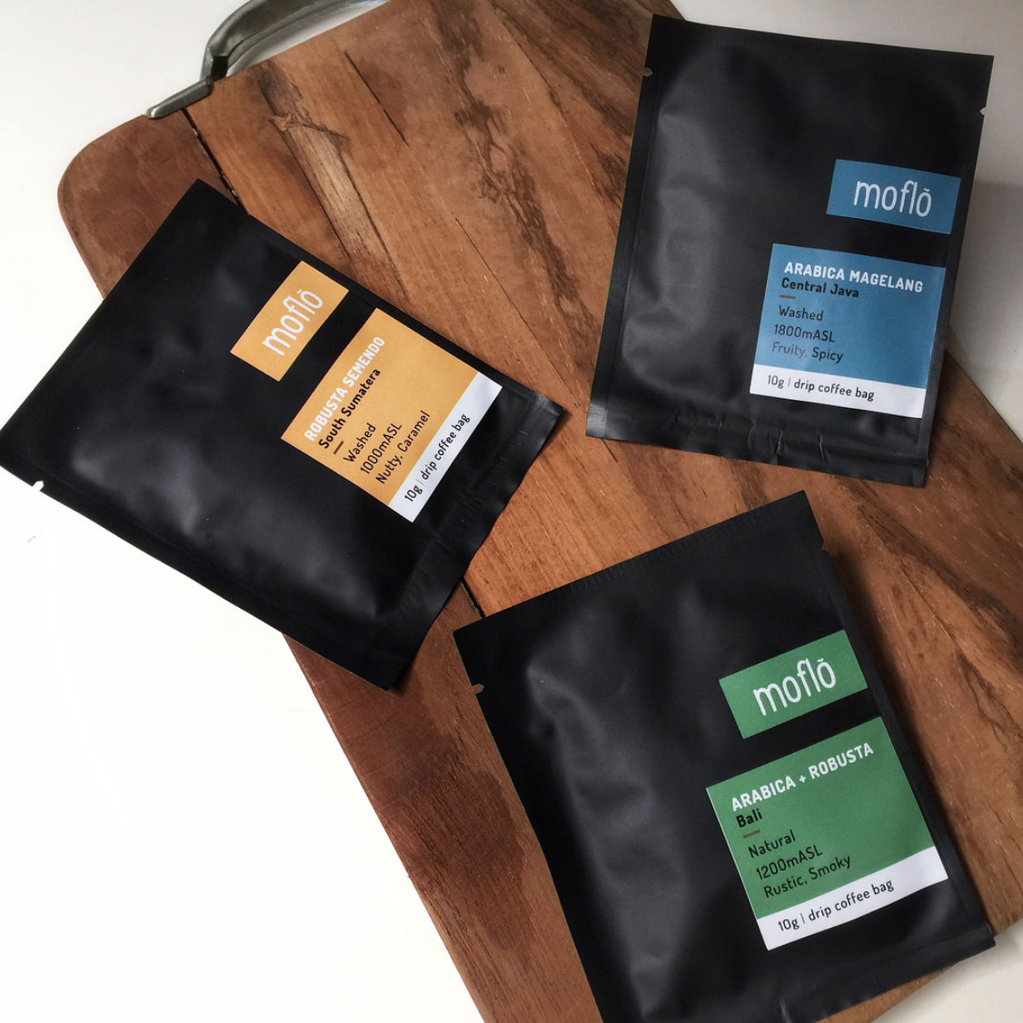 Hands holding Morlinka “Clean as a Whistle” crystal mist bottles, emphasizing modern packaging and a clean lifestyle aesthetic.