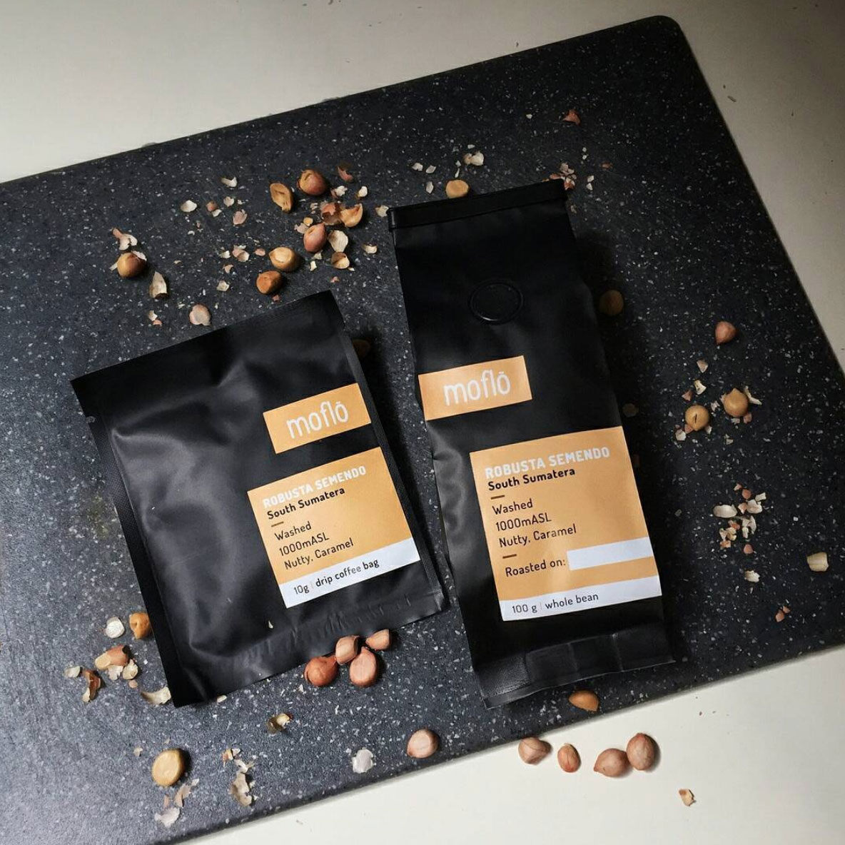 Two Morlinka scented wax tablets hanging from a wooden hanger against a soft fabric background, showcasing elegant and minimal branding.