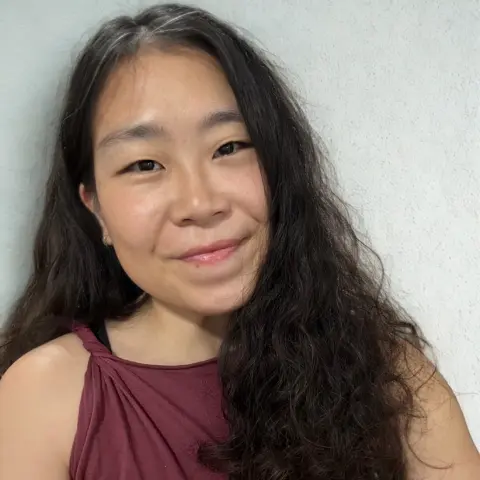 Morla posing in front of a beige wall 